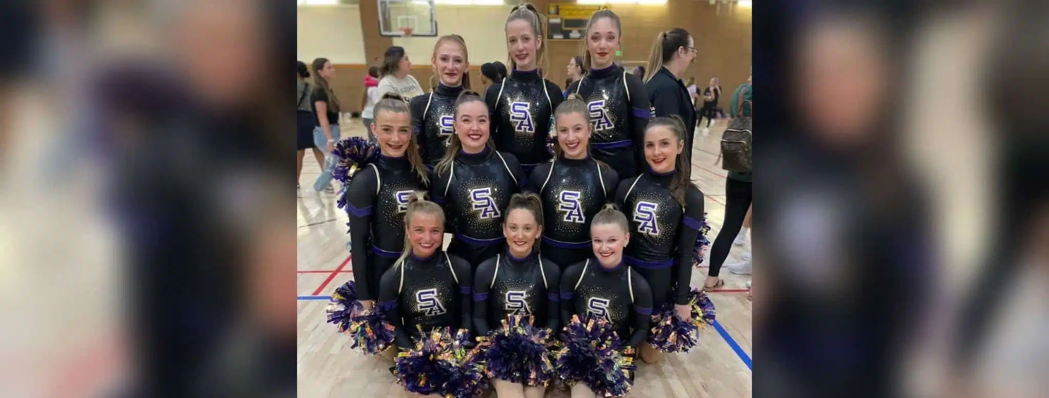 Flashettes dance team members posing in cheer outfits with pom-poms, celebrating the — Flashettes dance team Nationals bid