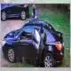 A black car with an open door parked on grass, with a person standing nearby, rela — child injured in Jackson park robbery