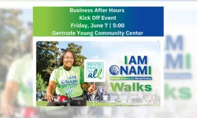 A woman in a green shirt promoting NAMI Vicksburg Walk for Mental Health at a community event.