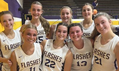 St. Aloysius girls' basketball team celebrating their season opening win with smiles and team jerseys.