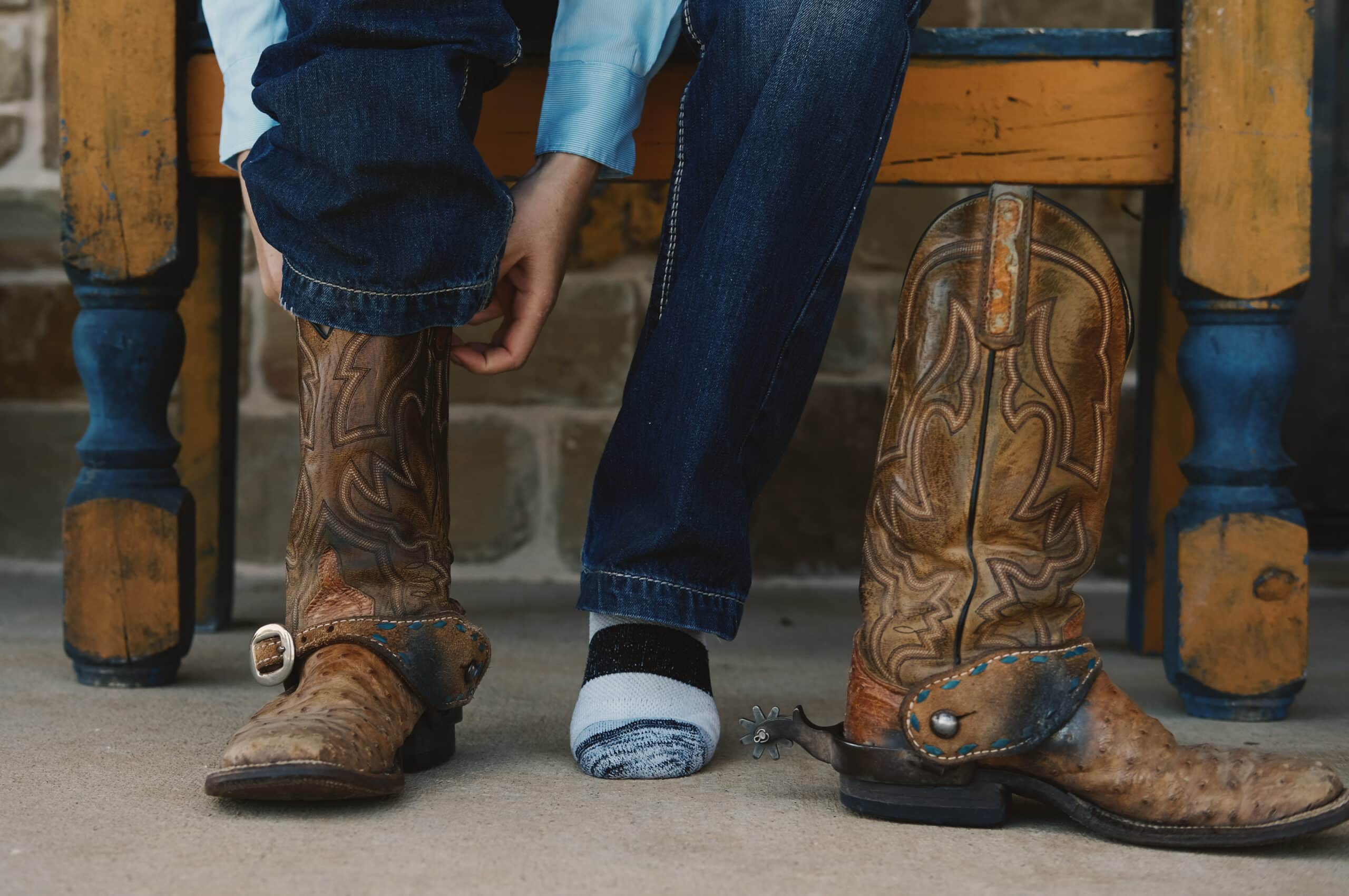Woman putting cowboy boots on close up for work.