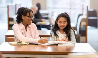Elementary girl reads with adult