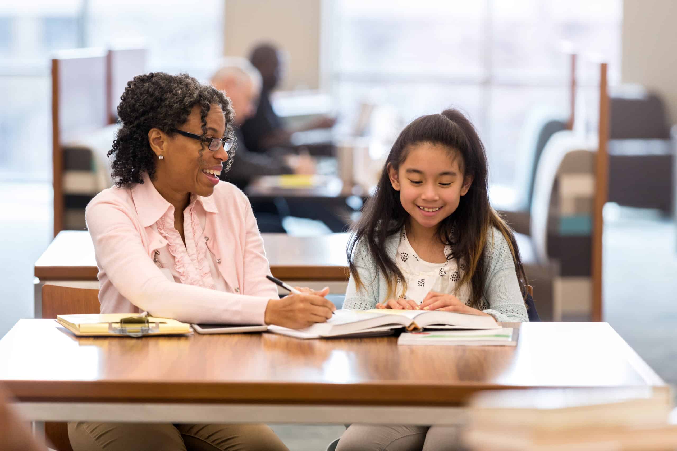 Elementary girl reads with adult