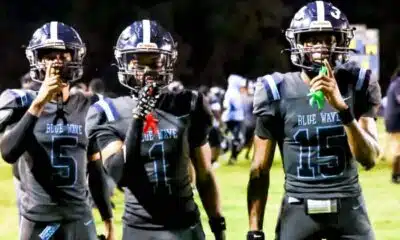 Three Port Gibson football players in black uniforms celebrate on the field after a play during the s — Port Gibson season
