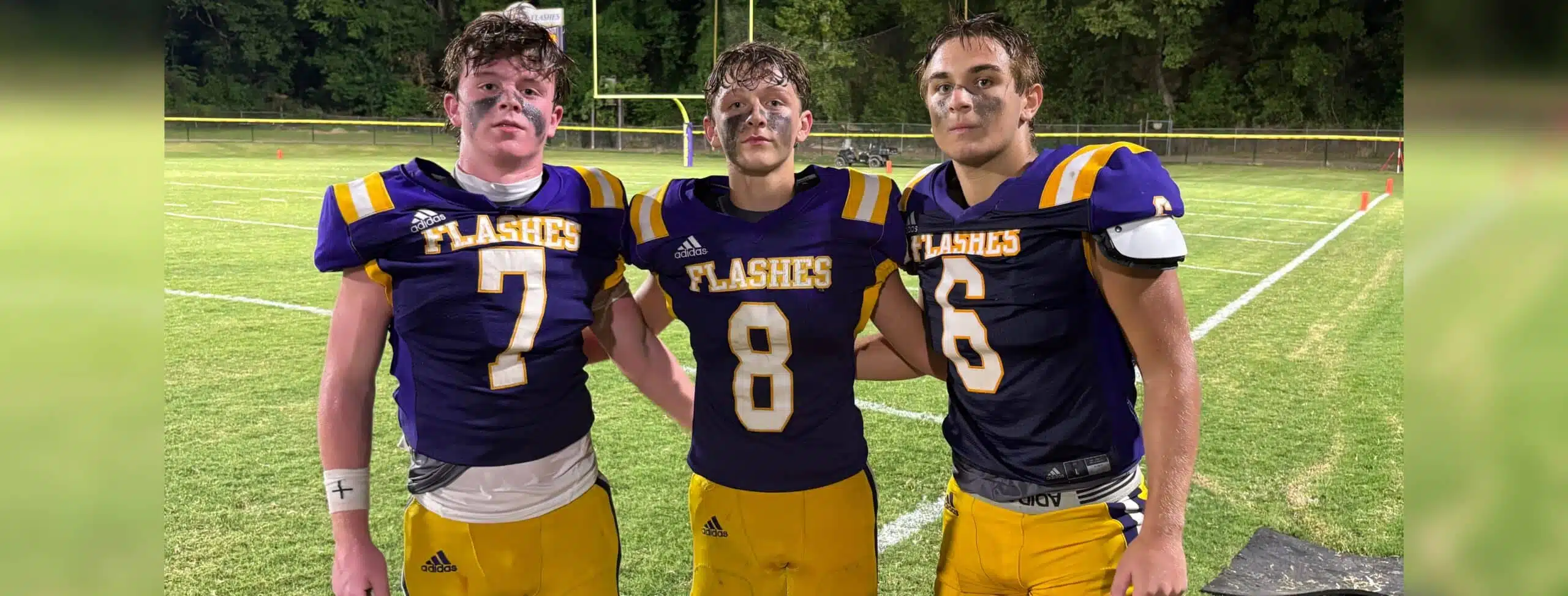 Three St. Aloysius Junior High football players celebrating after a game, wearing purple and gold uniforms, with a — 42-8