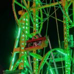 Brightly lit Ferris wheel at night, showcasing vibrant green lights at the Yazoo Fair.