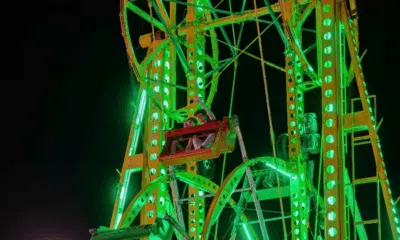 Brightly lit Ferris wheel at night, showcasing vibrant green lights at the Yazoo Fair.