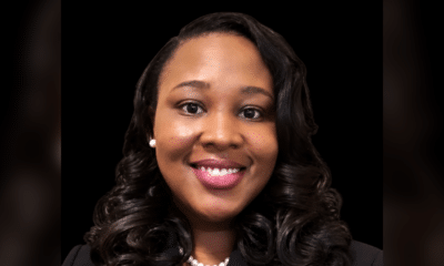 Smiling woman with curly hair wearing a black blazer and pearl necklace, representing Dr. Danielle Nelson.