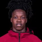 Michael Hall, a young athlete with long dark hair, wearing a red jacket, looking directly at the camera.