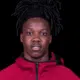 Michael Hall, a young athlete with long dark hair, wearing a red jacket, looking directly at the camera.