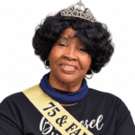 A woman wearing a tiara and sash celebrating her 75th birthday, smiling warmly. — Roberta Anderson