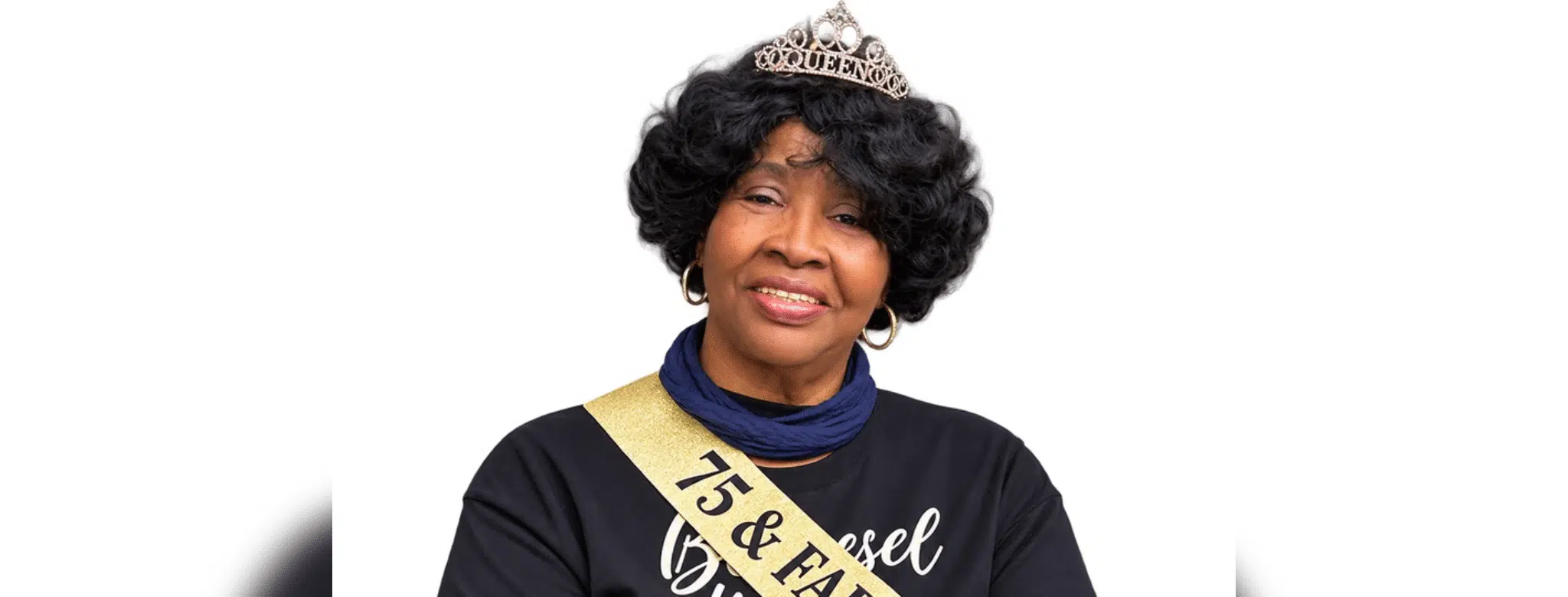 A woman wearing a tiara and sash celebrating her 75th birthday, smiling warmly. — Roberta Anderson