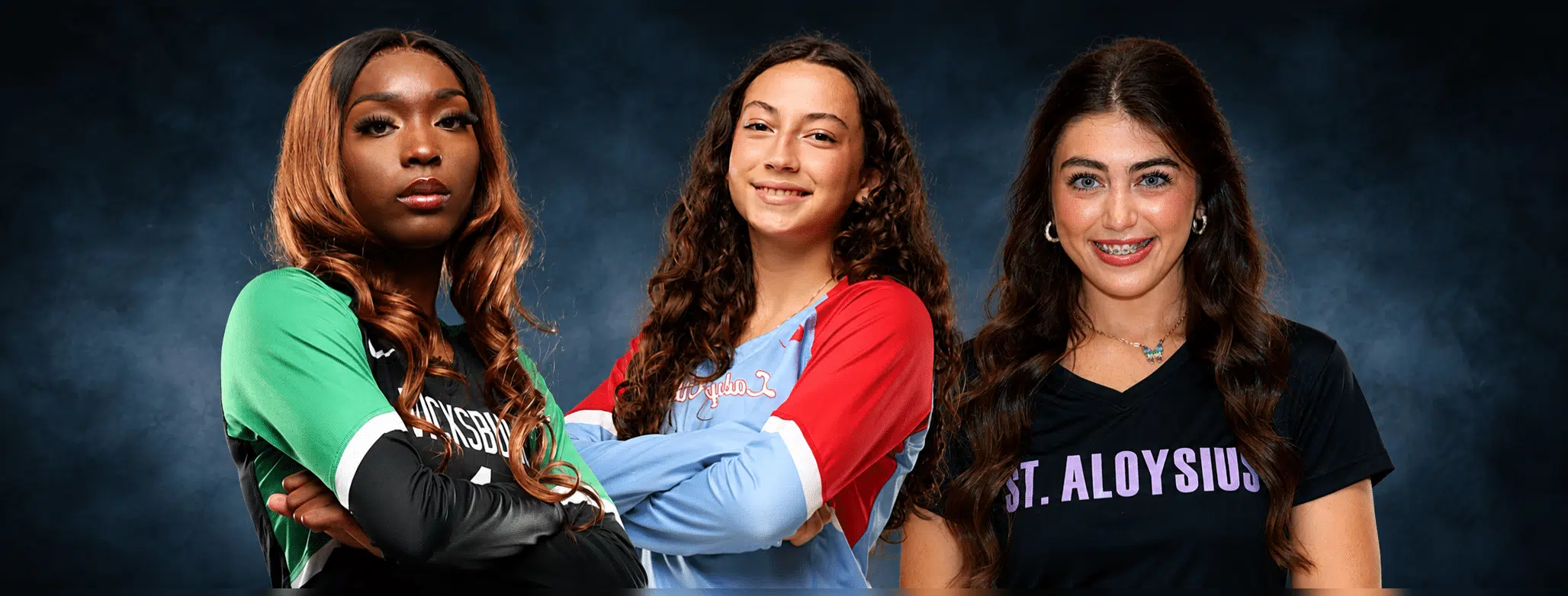 Three volleyball players from Vicksburg, Warren Central, and St. Aloysius pose confidently in their team jerseys.