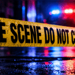 Police tape reading 'CRIME SCENE DO NOT CROSS' at a wet scene with emergency — Teenager shot in Vicksburg on Friday night