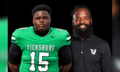 Vicksburg High School football player in green jersey and coach in black shirt, both posing for a photo. — Gators 35-0