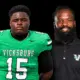 Vicksburg High School football player in green jersey and coach in black shirt, both posing for a photo. — Gators 35-0