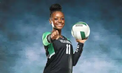 A volleyball player in a black uniform holds a volleyball and points confidently at the camera, sho — Vicksburg volleyball