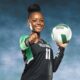 A volleyball player in a black uniform holds a volleyball and points confidently at the camera, sho — Vicksburg volleyball
