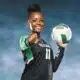 A volleyball player in a black uniform holds a volleyball and points confidently at the camera, sho — Vicksburg volleyball