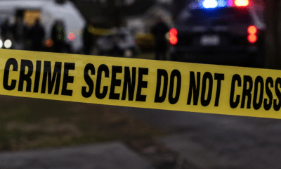 Yellow crime scene tape reading 'CRIME SCENE DO NOT CROSS' at a police investigation site. — Capital murder — custody