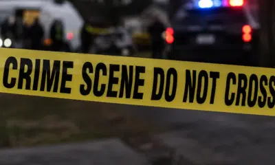 Yellow crime scene tape reading 'CRIME SCENE DO NOT CROSS' at a police investigation site. — Capital murder — custody