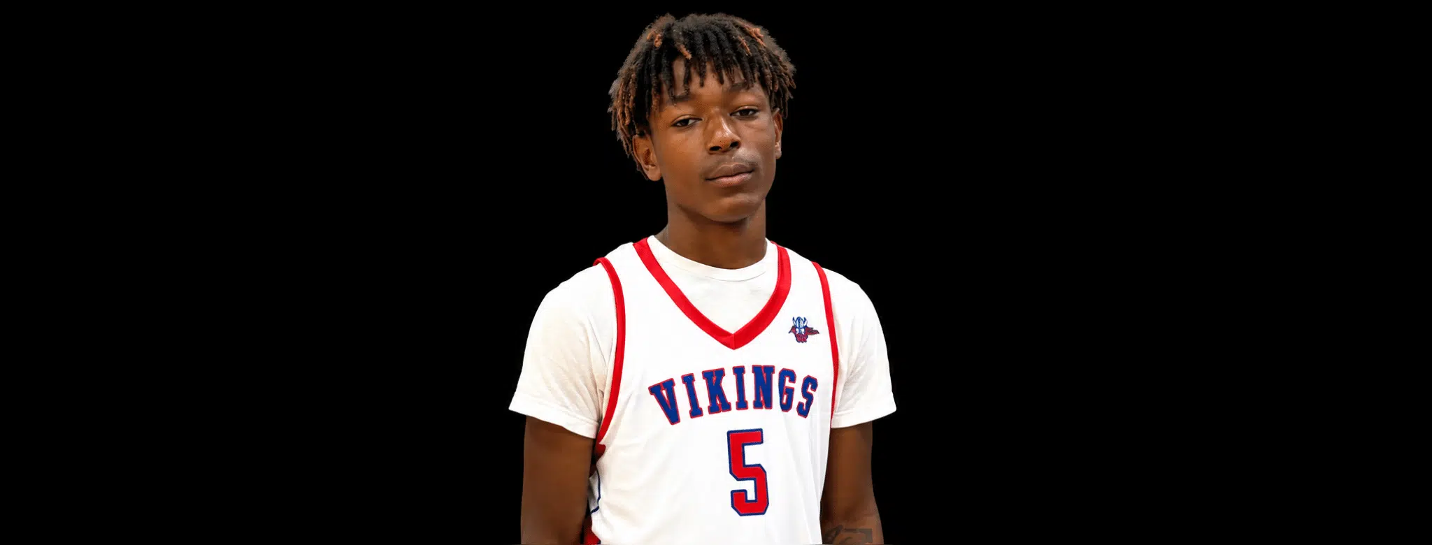 A young male athlete wearing a white basketball jersey with 'Vikings' and the number 5, standing against a — 16 identified