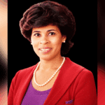 Portrait of Vicki Roach Barnes, a distinguished judge, wearing a red blazer and pearls.