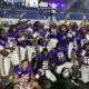 Alcorn football team celebrates victory at the Southern Heritage Classic, holding a trophy and posing for the camera.
