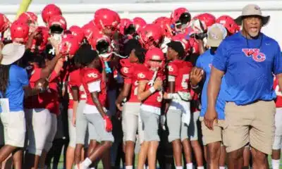 WCJHS football team in red uniforms celebrating with their coach a — WCJHS made a comeback to defeat Madison Central 26-14