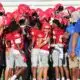 WCJHS football team in red uniforms celebrating with their coach a — WCJHS made a comeback to defeat Madison Central 26-14