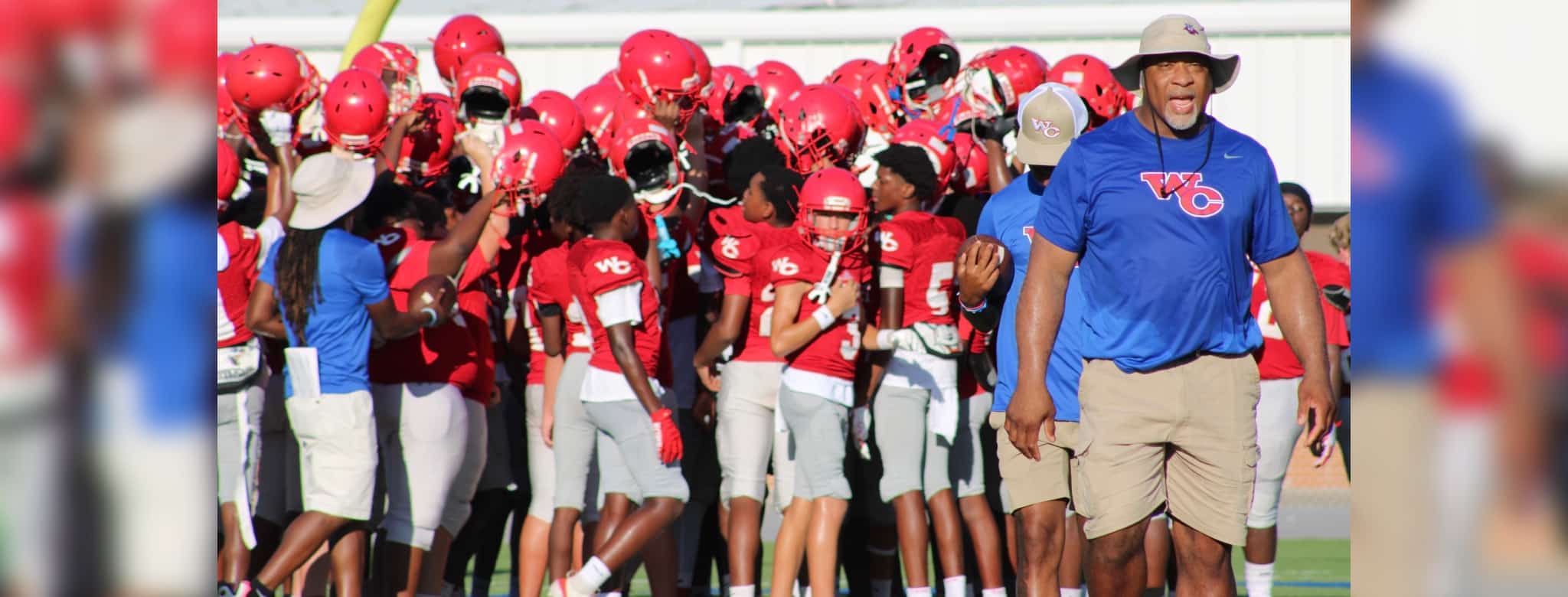 WCJHS football team in red uniforms celebrating with their coach a — WCJHS made a comeback to defeat Madison Central 26-14