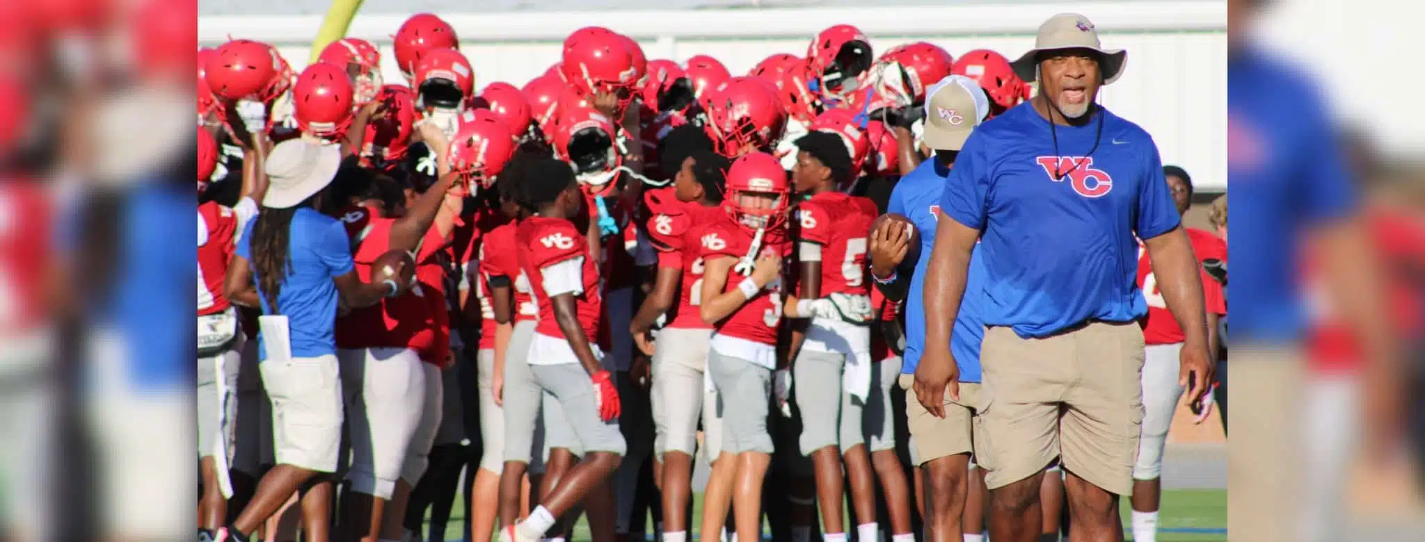 WCJHS football team in red uniforms celebrating with their coach a — WCJHS made a comeback to defeat Madison Central 26-14