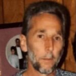 A man with a beard and short hair, looking directly at the camera, with a blurred backgr — Ronald “Ronnie” Lynn McLeod