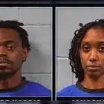 Two individuals in blue police uniforms, one male and one female, with a police backdrop related to the Halls Ferry shooting.