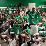 VJHS football team celebrating in locker room after their 4-0 victory, showing team spirit and exci — VJHS improves to 4-0