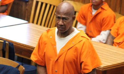 A man in an orange prison jumpsuit stands in a courtroom, looking serious, with other individuals se — Failure to register