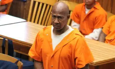 A man in an orange prison jumpsuit stands in a courtroom, looking serious, with other individuals se — Failure to register