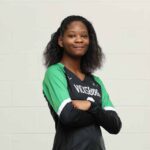 A confident volleyball player from Vicksburg High School poses with arms crossed, wearing — VHS volleyball defeats Canton