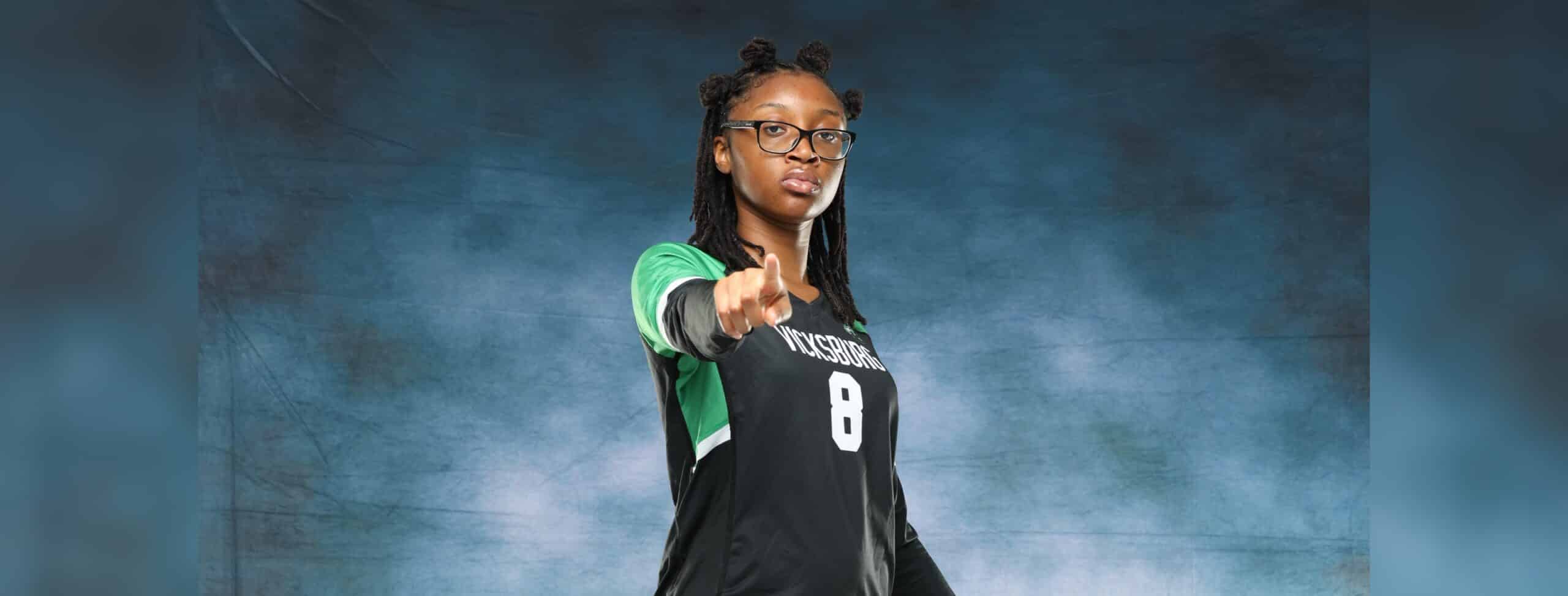 A Vicksburg High School volleyball player in a black jersey points confidently at the came — VHS volleyball defeats Canton