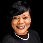 Rashandra Laws, a nurse practitioner, smiling in a professional setting with a black background.