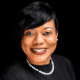 Rashandra Laws, a nurse practitioner, smiling in a professional setting with a black background.