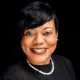 Rashandra Laws, a nurse practitioner, smiling in a professional setting with a black background.