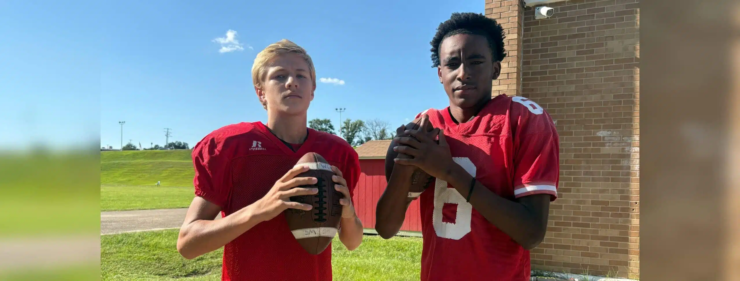 Two young football players in red jerseys, one holdin — Morgan throws three touchdowns; Miles scores four in WCJHS victory