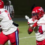 Warren Central football players in red uniforms during a game against Vicksburg High, showcasing action on the fiel — 15th