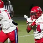 Warren Central football players in red uniforms during a game against Vicksburg High, showcasing action on the fiel — 15th