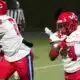 Warren Central football players in red uniforms during a game against Vicksburg High, showcasing action on the fiel — 15th