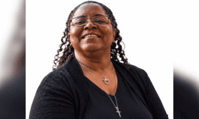 Smiling woman with curly hair wearing glasses and a black sweater, exuding warmth and positivity. — Pamela Williams