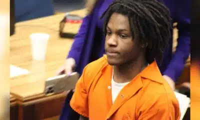 An 18-year-old in an orange jumpsuit sits in a courtroom, looking serious during sentencing. — 18 year old