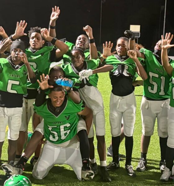 Vicksburg Junior High School football team celebrating after their victory, wearing green jerseys and posing — Little Six