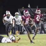 Hinds CC football player running with the ball while defenders chase during a game, celebrating a touchdown. — 52-28
